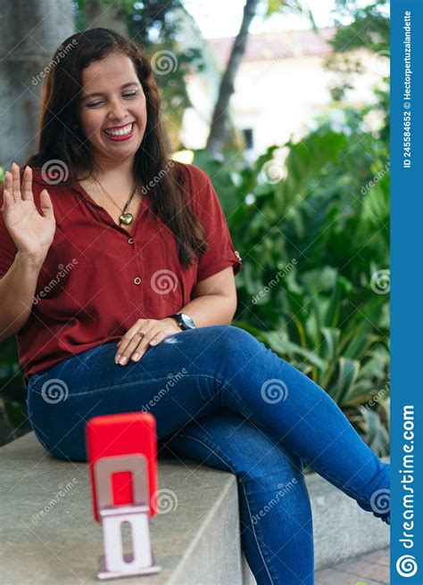 Hispanic Female Vlogger Recording Content For Her Vlog With A Mobile Phone While Sitting On A