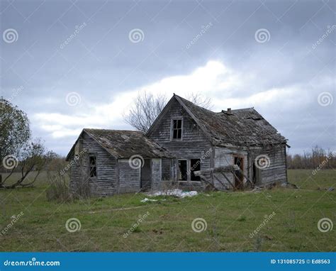 Dreary Abandoned Dilapidated Farm House With Cloudy Skies Stock Image