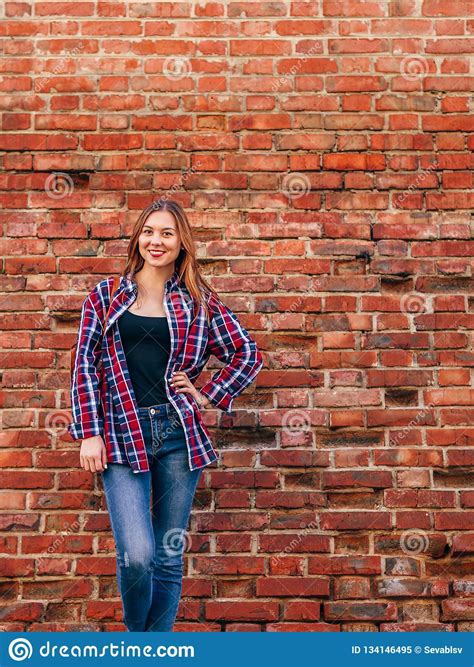 Portrait Of Young Woman Standing Against Brick Wall Stock Image Image