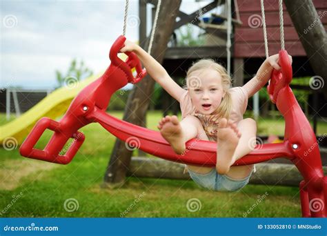 Cute Little Girl Having Fun On A Playground Outdoors In Summer Stock