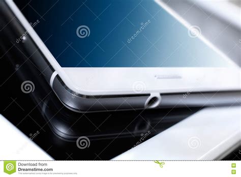 White Business Smartphone With Blue Reflection Lying On White Tablet