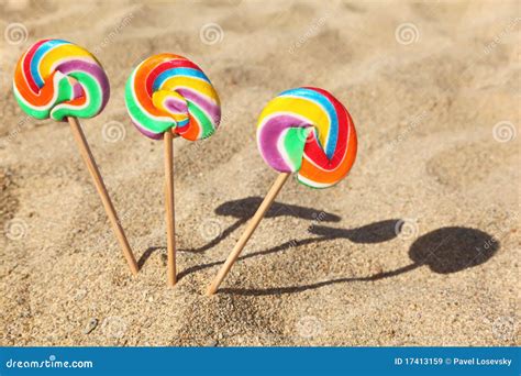 Três Lollipops Sticked Na Areia Na Praia Imagem De Stock Imagem De
