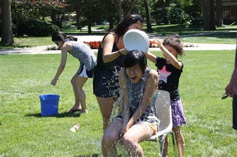 Campers Dumping A Bucket Of Water On Another During Their Annual Water
