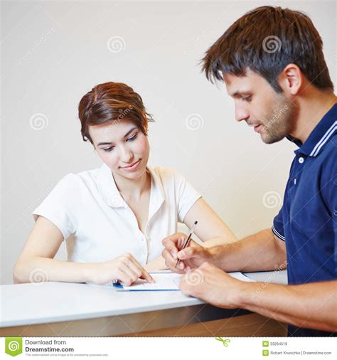 Man Filling Out Patient Form At Doctors Office Royalty