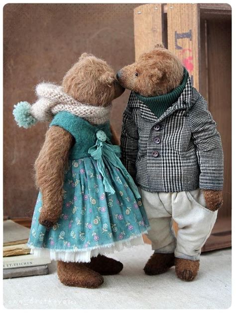 Two Teddy Bears Dressed In Clothes Standing Next To Each Other On The Ground And Kissing