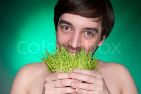 Young Man Eating A Bunch Of Fresh Green Stock Image Colourbox