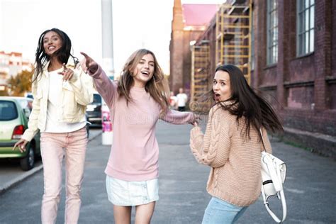 Outdoor Shot Of Three Young Women Having Fun On City Street Stock Photo