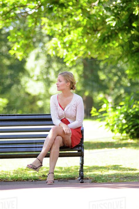 Young Woman Sitting On Park Bench Stock Photo Dissolve