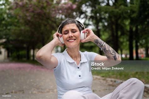 ヘッドフォンを持つ一人の成熟した年配の女性が屋外で幸せに音楽を聴く 1人のストックフォトや画像を多数ご用意 1人 45 49歳 つながり Istock