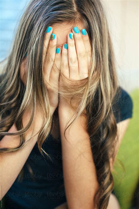 Teenage Girl With Long Hair Covering Her Face With Her Hands By Stocksy Contributor Carolyn