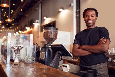 Portrait Of Male Coffee Shop Owner Standing At Sales Desk Stock Image