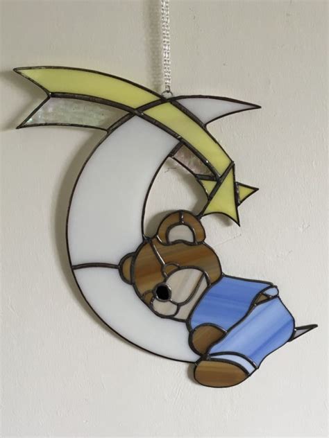 A Stained Glass Sun Catcher With A Teddy Bear On The Moon Hanging From