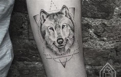 A Black And White Photo Of A Wolfs Head On The Left Forearm With An Arrow