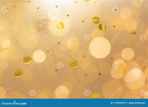 Gold Confetti And Glitter On Beige Metallic Shiny Background With Blur