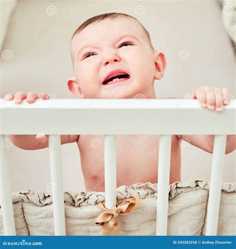 A Sad Baby Is Crying In A Crib Holding Onto The Handrails Funny Lop