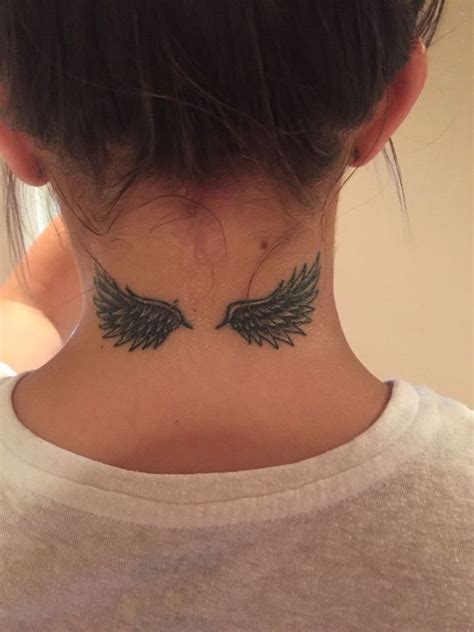 Small Angel Wings Tattoo On Back Woman With White T Shirt Brown Hair In