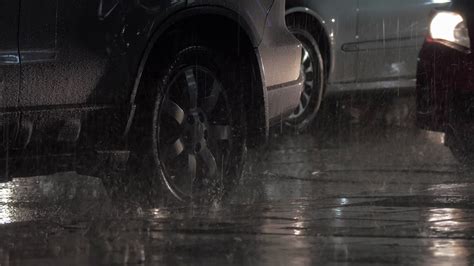 Two Cars Parked At The Roadside Under The Heavy Rain In