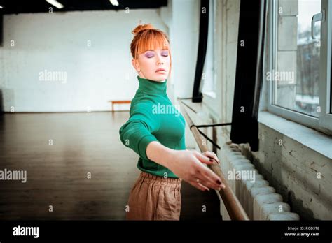 Red Haired Professional Ballet Dancer With Hair Bun Looking Focused