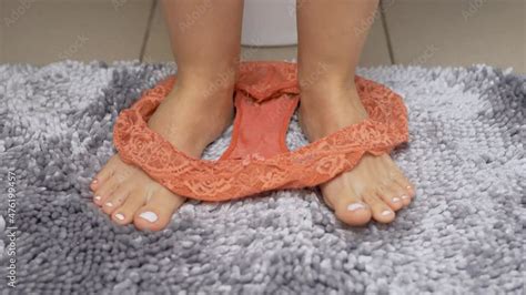 bottom part of girl sitting on toilet seat in bathroom toilet close up of girl s feet and