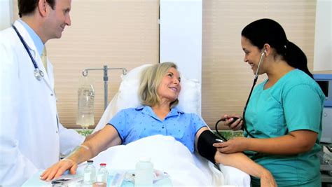 Hispanic Nursing Aide Checking Blood Pressure Senior Caucasian Female
