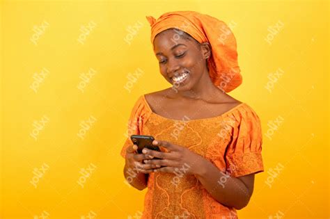 femme africaine souriante en bazin en manipulant son téléphone photo 8832 jolixi banque d