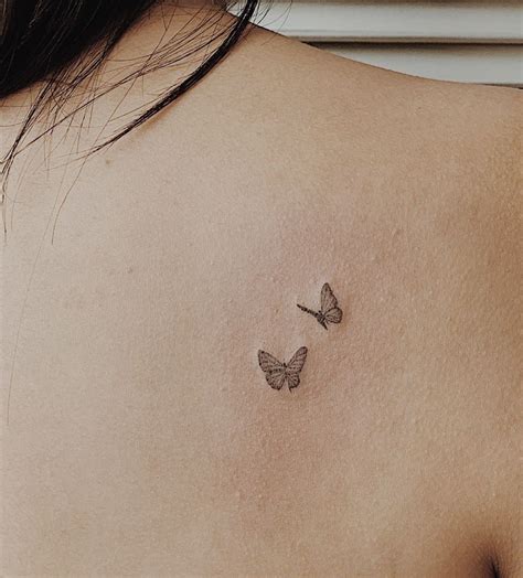 Two Butterflies On The Back Of A Woman S Shoulder