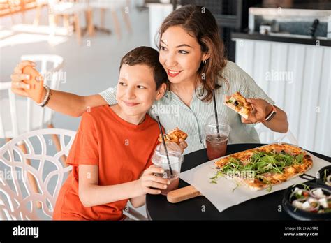 Madre E Hijo Se Lo Pasaban Bien En Un Café Comiendo Pizza Y Tomando