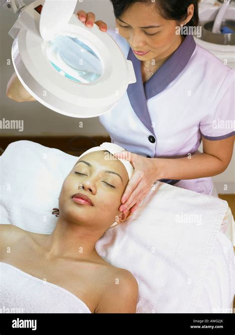 Beautician Giving Facial Treatment To Young Woman Stock Photo Alamy