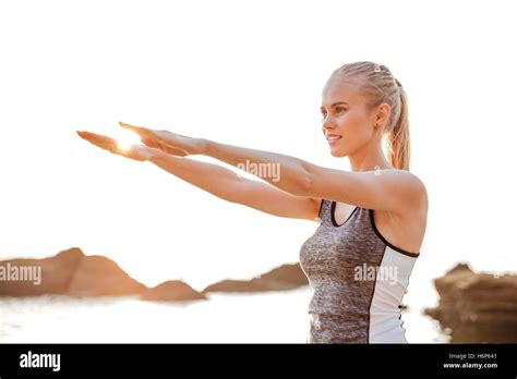 Close Up Portrait Of A Beautiful Young Woman Stretching Hands Exercises During Yoga On The Beach