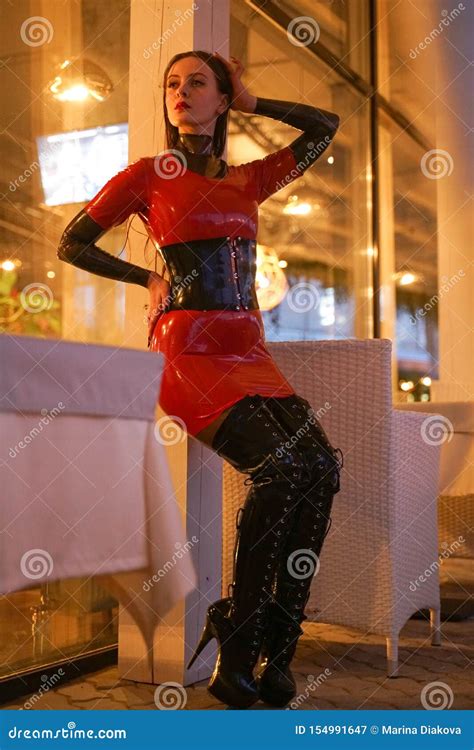 brave girl in latex walks in public and shows her exhibitionism stock