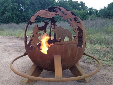 An Outdoor Fire Pit With Metal Animals On Its Sides And Flames In The