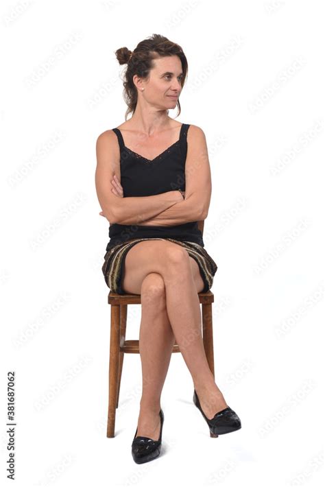 Side View Of A Woman In Skirt Sitting On A Chair On White Background