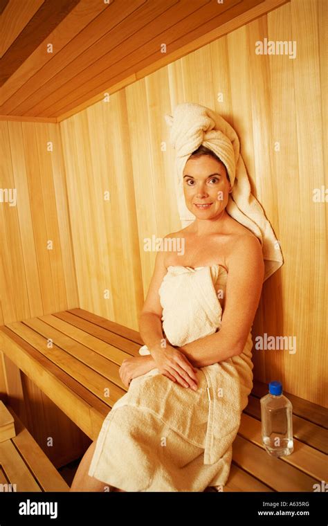 Portrait Of A Mature Woman Wearing Towel Sitting In A Sauna Stock Photo