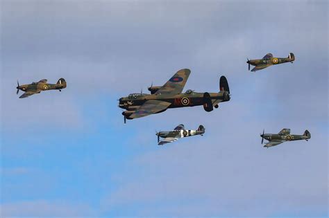 People Watch On In Awe As Historic Lancaster Spitfires And Hurricane