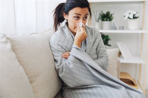 Woman Cold Headache Runny Nose And Stuffy Nose Sitting On Sofa In Plaid Treatment For Flu