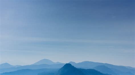 Pale Silhouettes Of Mountain Ridges Under A Blue Sky Blue Mountain