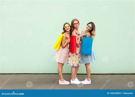 schöne drei freunde des glückes in den gläsern mit bunten paketen nach dem einkauf stockfoto