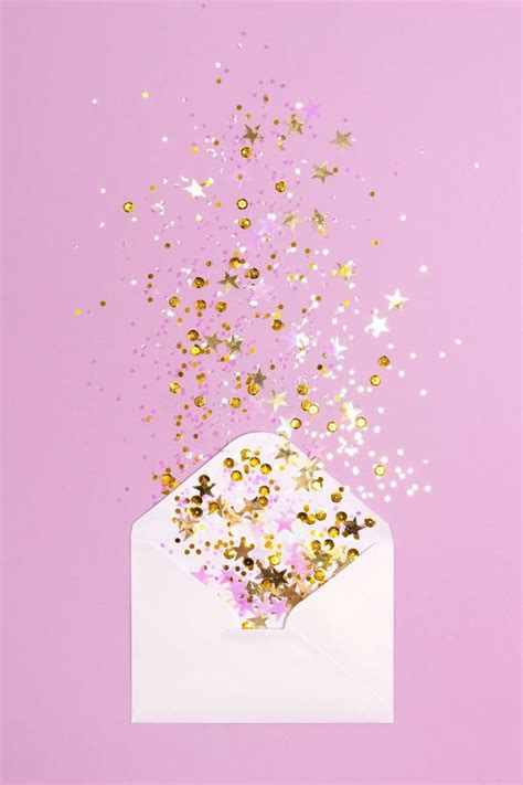 Golden And Pink Confetti Scattered From Envelope On Pastel Pink