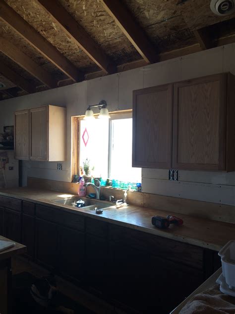 I have a 9' run where i am installing upper cabinets, the floor and the ceiling a significantly sloped (i have not set them yet but it looks like if. Upper cabinets installed in our offgrid kitchen ...
