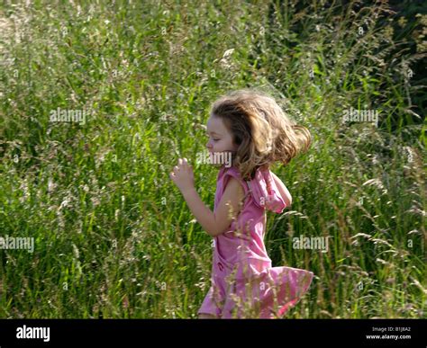Little Girl Running Through Grass Stock Photo Alamy