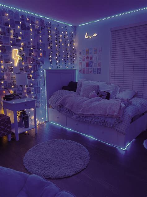 A Bedroom Decorated In Purple And White With Lights On The Walls