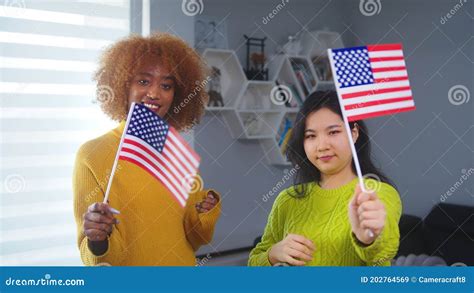 Multiracial Friendship And Equality African American And Asian Woman Holding Usa Flags Stock