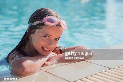 Cheerful Girl With Swimming Goggle On The Edge Of A Swimming Pool High