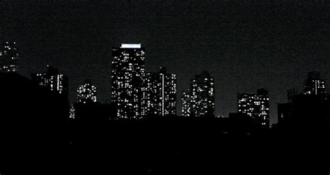 The City Skyline Is Lit Up At Night In Black And White With Lights