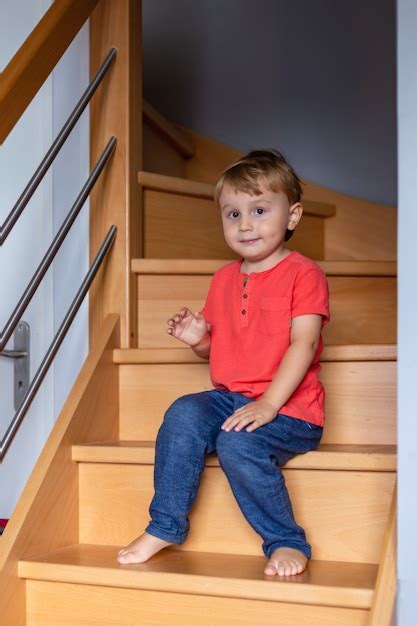 Premium Photo Little Boy Waering T Shirt Is Sitting On The Stairs At