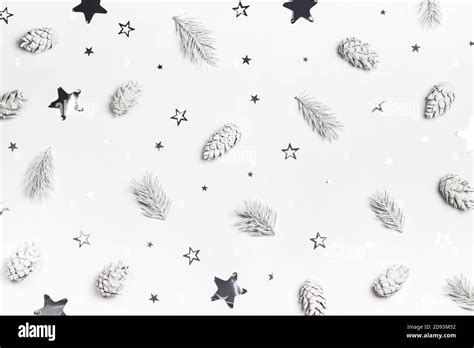 White Christmas Or New Year Background With Pines And Silver Star Shaped Confetti Top View