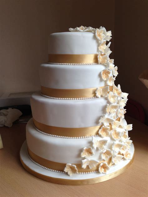 White And Gold Wedding Cake With Cascading Flowers And Butterflies