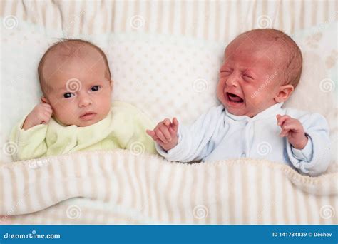 Two Adorable Twin Babies One Looking One Crying Stock Image Image