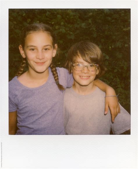 instant film photo of a big sister and her little brother they re totes bffs by stocksy
