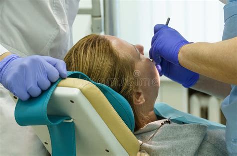 The Dentist Treats The Teeth Of The Patient In The Clinic Stock Photo